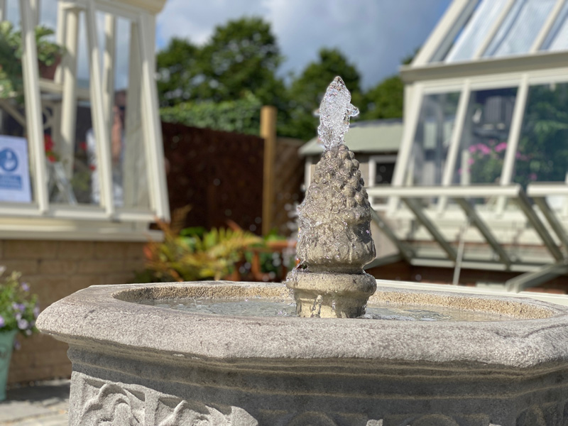Stone fountain spurting water at Hampton Court flower show