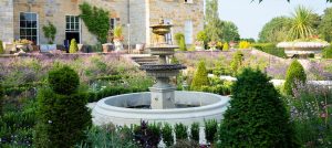 A grand three tier Chilstone fountain in a formal garden design.