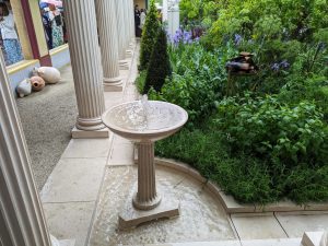 A Roman inspired courtyard garden with fluted columns and petite birdbath shaped small fountains.